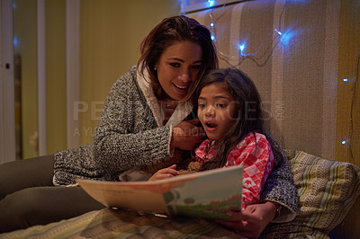 Buy stock photo Shot of mother reading a bedtime story with her daughter at bedtime