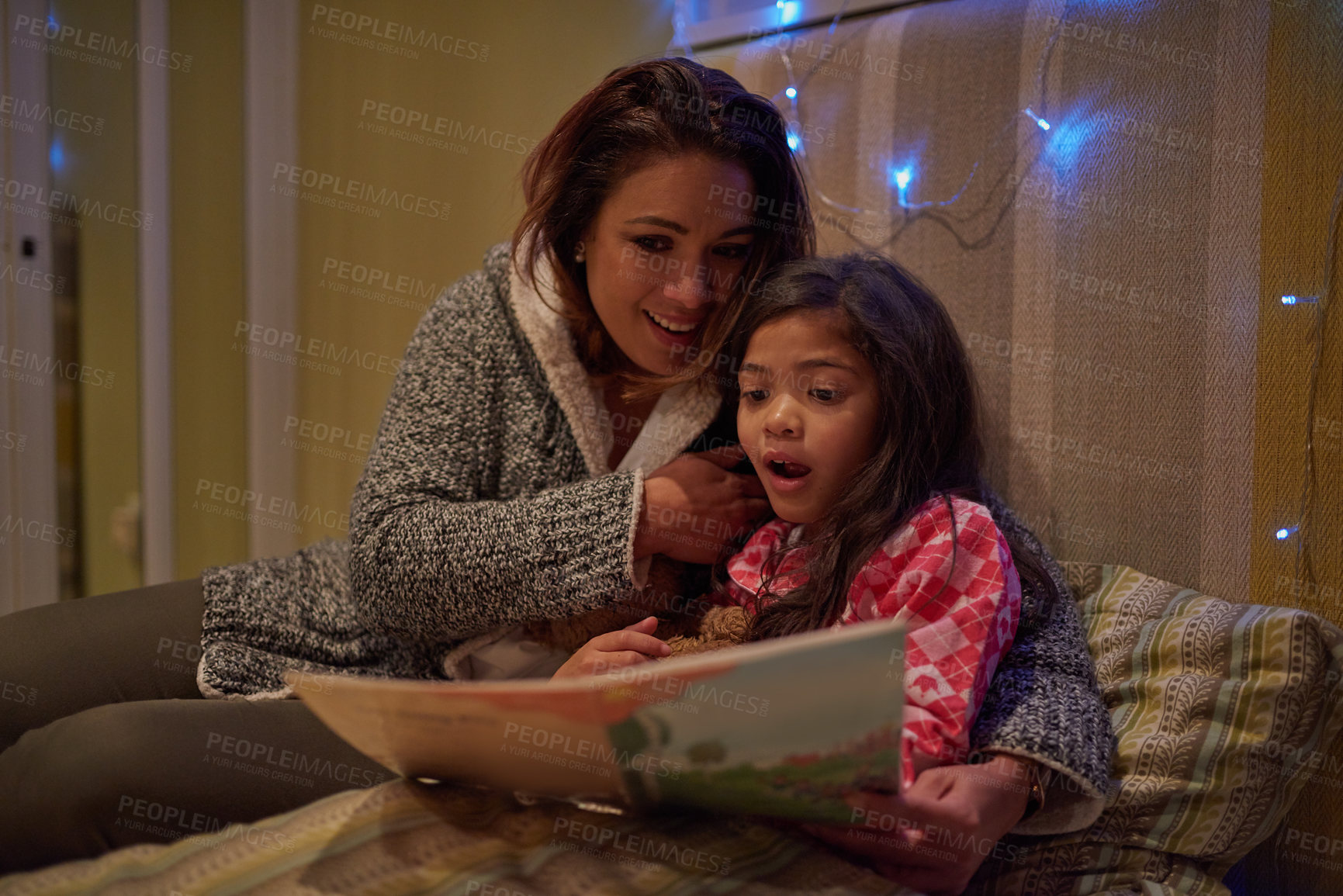 Buy stock photo Shot of mother reading a bedtime story with her daughter at bedtime