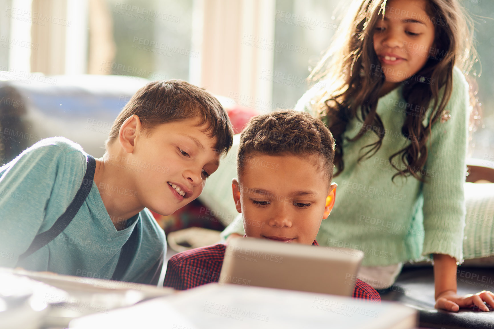 Buy stock photo Shot of young children using a digital tablet together at home