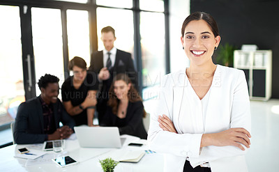 Buy stock photo Portrait of a businesswoman standing in a boardroom meeting with colleagues in the background