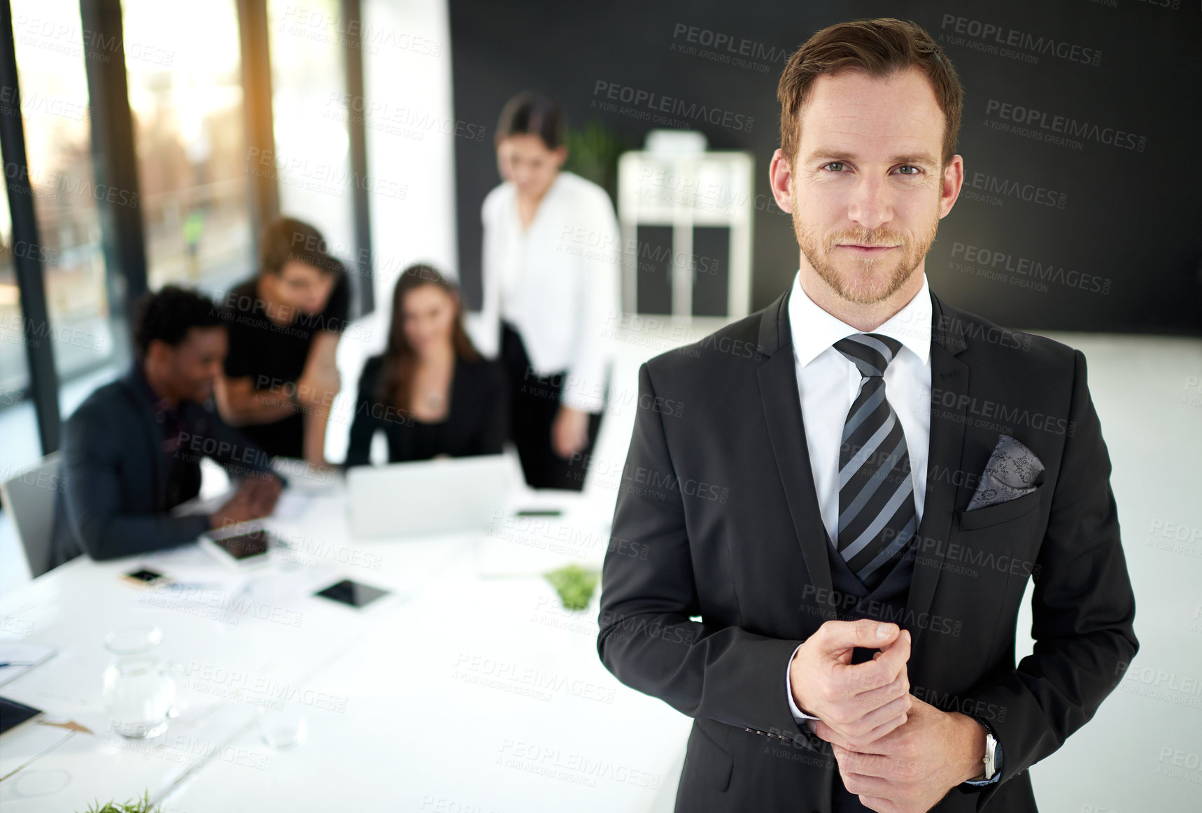 Buy stock photo Portrait of a businessman standing in a boardroom meeting with colleagues in the background