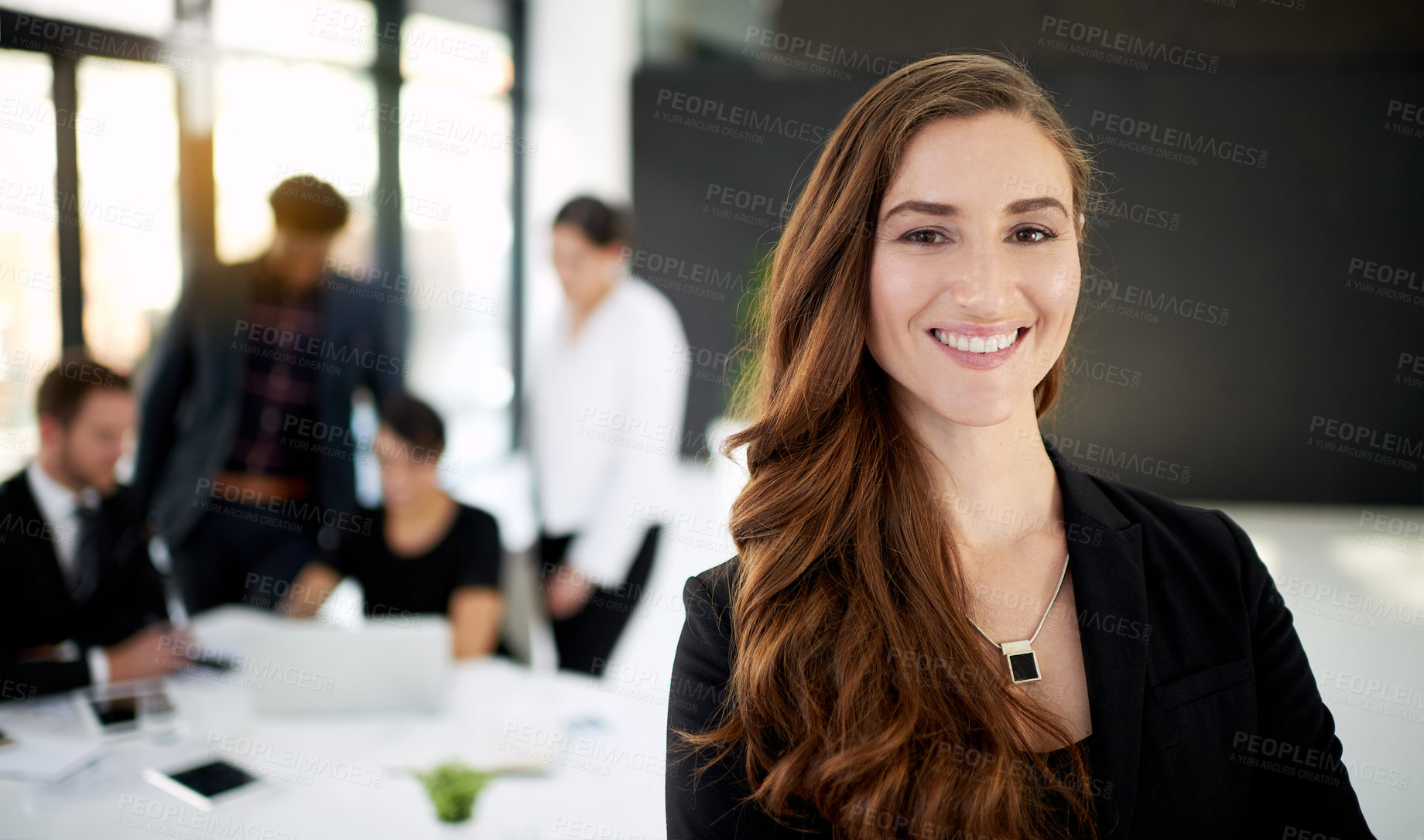 Buy stock photo Portrait of a businesswoman standing in a boardroom meeting with colleagues in the background