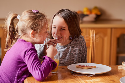 Buy stock photo Cropped shot of a smiling little girl having breakfast with her sister in the kitchen