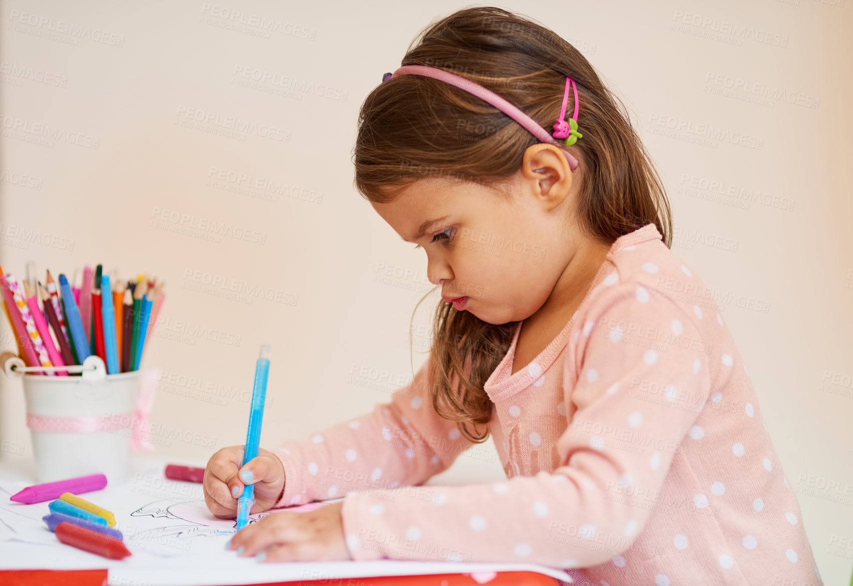 Buy stock photo Cropped shot of a little girl colouring in a picture at home