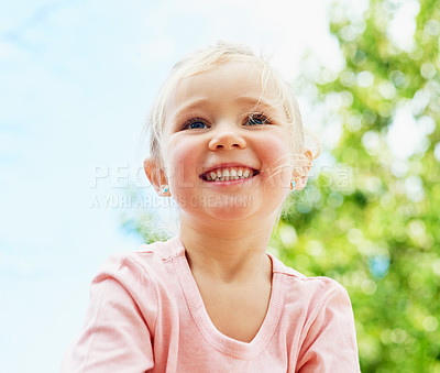 Buy stock photo Shot of a cute little girl smiling while playing outside