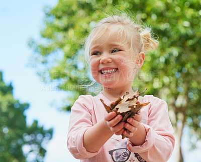 Buy stock photo Girl, leaves and play outdoors for fun, learning nature and child development in park playground. Female person, kid and happy or outside curious, plants and countryside discovery or explore trees