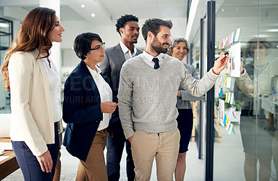 Buy stock photo Business people, brainstorming or man writing on board for planning or speaking of solution or team ideas. Group goal, sticky note or employees in meeting with leadership for problem solving together