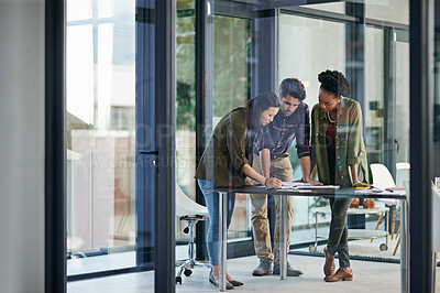 Buy stock photo Shot of a group of young creatives having a discussion in an office