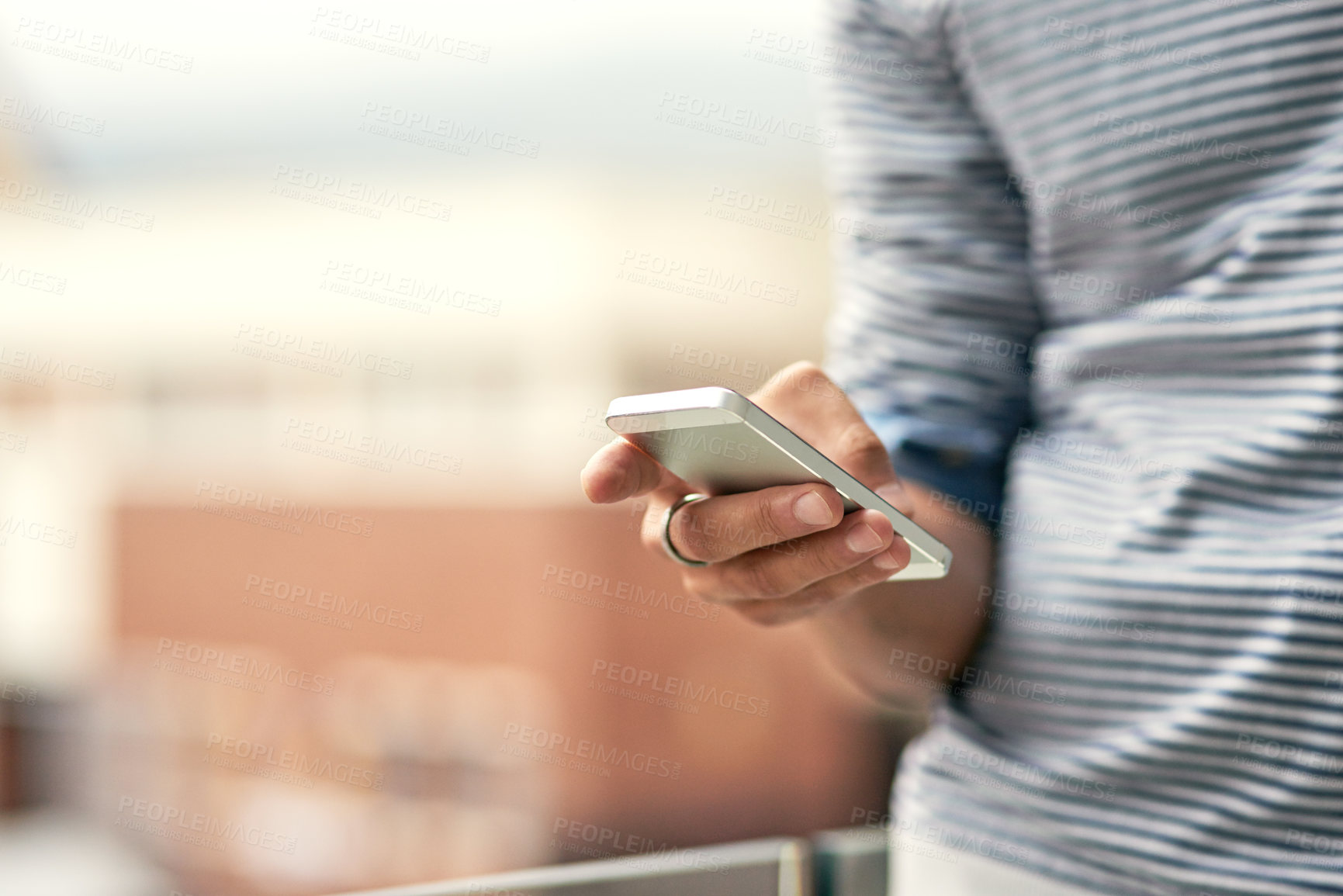 Buy stock photo Closeup shot of a young man texting on a cellphone outside