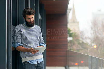 Buy stock photo Cropped shot of a young creative working on a digital tablet outside