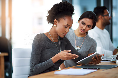 Buy stock photo Shot of coworkers trying to solve something on a digital tablet at work
