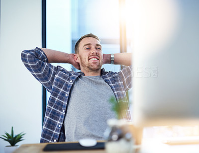 Buy stock photo Shot of a young businessman relaxing at his work desk