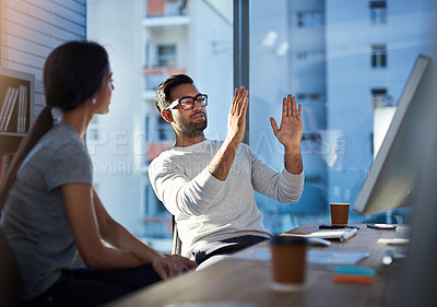 Buy stock photo Shot of a young businessman explaining an idea to his coworker at work