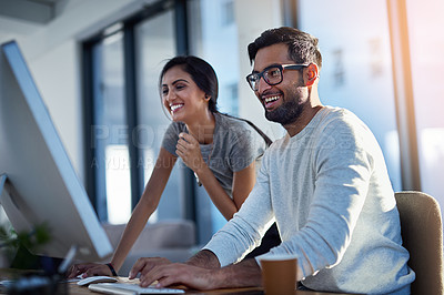 Buy stock photo Shot of two young coworkers using a computer together at work