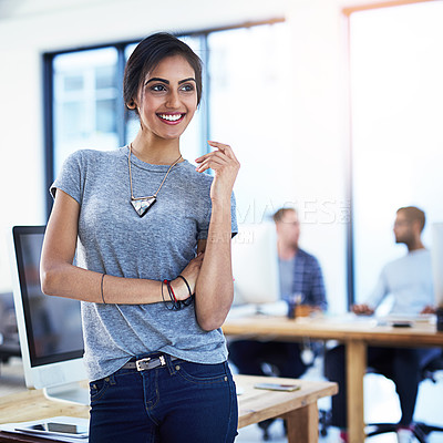 Buy stock photo Shot of a happy young businesswoman standing in an office with her team in the background