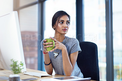 Buy stock photo Shot of a thoughtful young businesswoman having a coffee break at her desk