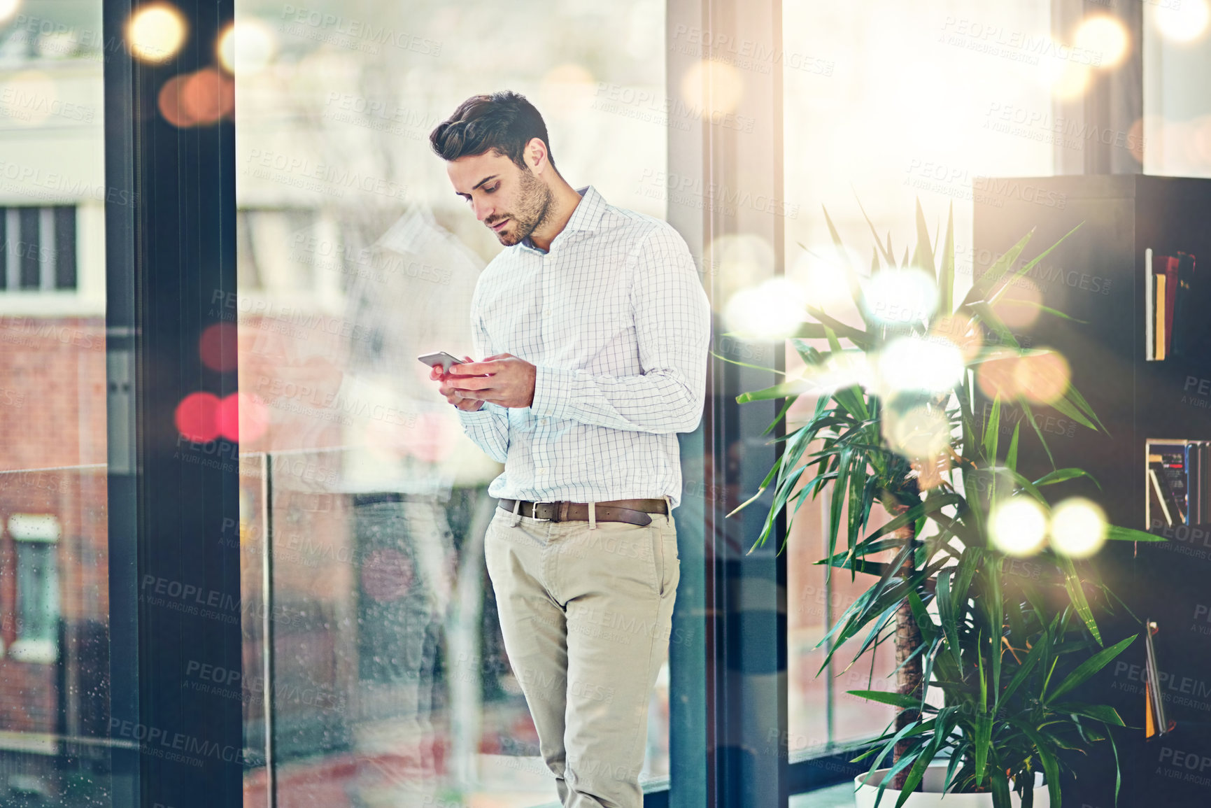 Buy stock photo Man, office and texting on smartphone for internet or check social media, post and messages. Business person, lens flare and window with communication or networking for news update and website