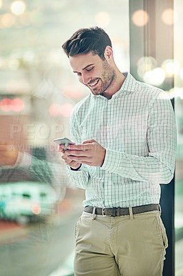Buy stock photo Cropped shot of a corporate businessman texting on a cellphone in an office