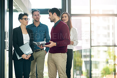 Buy stock photo Shot of a group of colleagues talking together in a large modern office