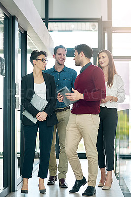 Buy stock photo Shot of a group of colleagues talking together in a large modern office