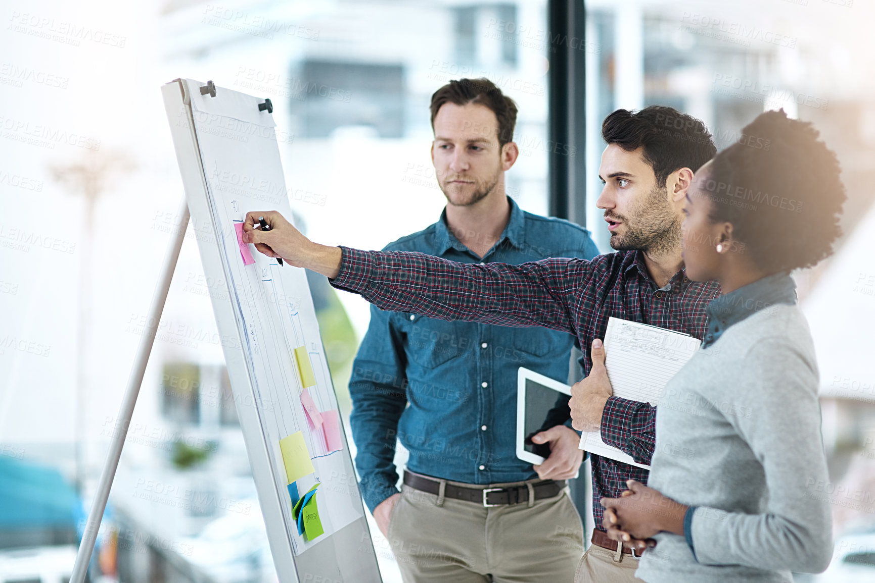 Buy stock photo Cropped shot of colleagues having a discussion using a whiteboard in an office