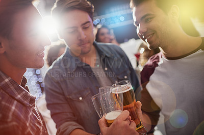 Buy stock photo Cropped shot of guys toasting with beers at a party