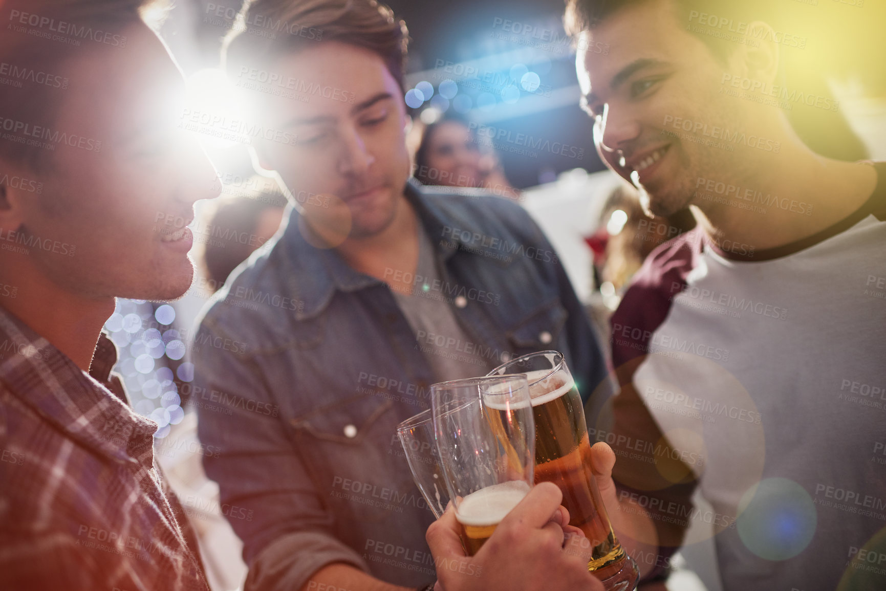 Buy stock photo Cropped shot of guys toasting with beers at a party