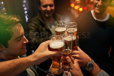 Buy stock photo High angle shot of guys toasting with beers at a party