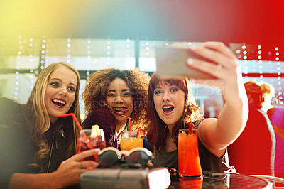 Buy stock photo Shot of young friends taking selfies while having drinks at a party