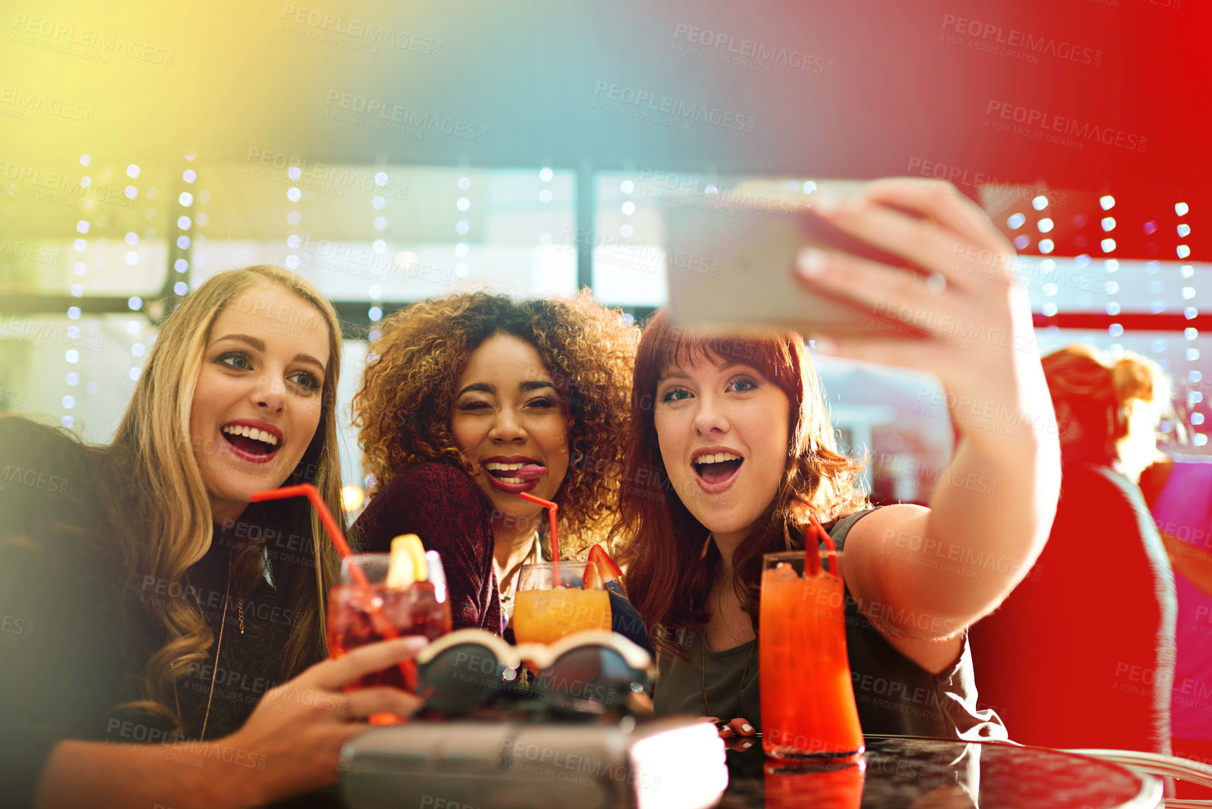 Buy stock photo Shot of young friends taking selfies while having drinks at a party