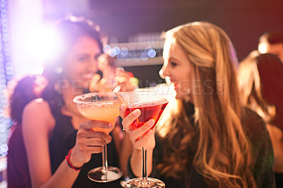 Buy stock photo Shot of two young women drinking cocktails at a party