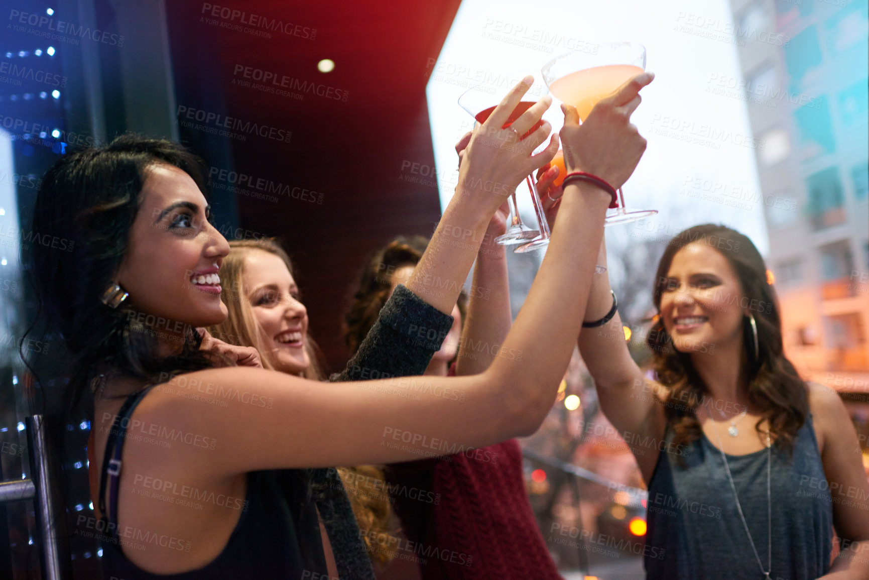Buy stock photo Women, friends and group cheers with cocktail at pub together for celebration, event or happy hour at night club. Toast, party and girls with alcohol glass at bar for social gathering, drink or smile