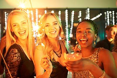 Buy stock photo Shot of a group of girlfriends having fun with sparklers on a night out