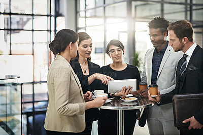 Buy stock photo Cropped shot of a group of businesspeople looking at a tablet in the office