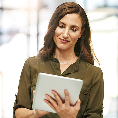 Buy stock photo Cropped shot of a young businesswoman using a digital tablet in an office