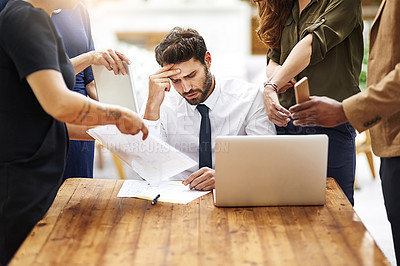 Buy stock photo Cropped shot of a stressed out businessman surrounded by colleagues needing help in an office