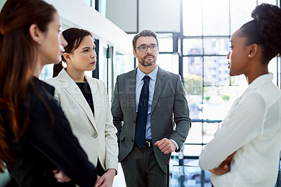 Buy stock photo Cropped shot of a group of businesspeople having a serious discussion in the office