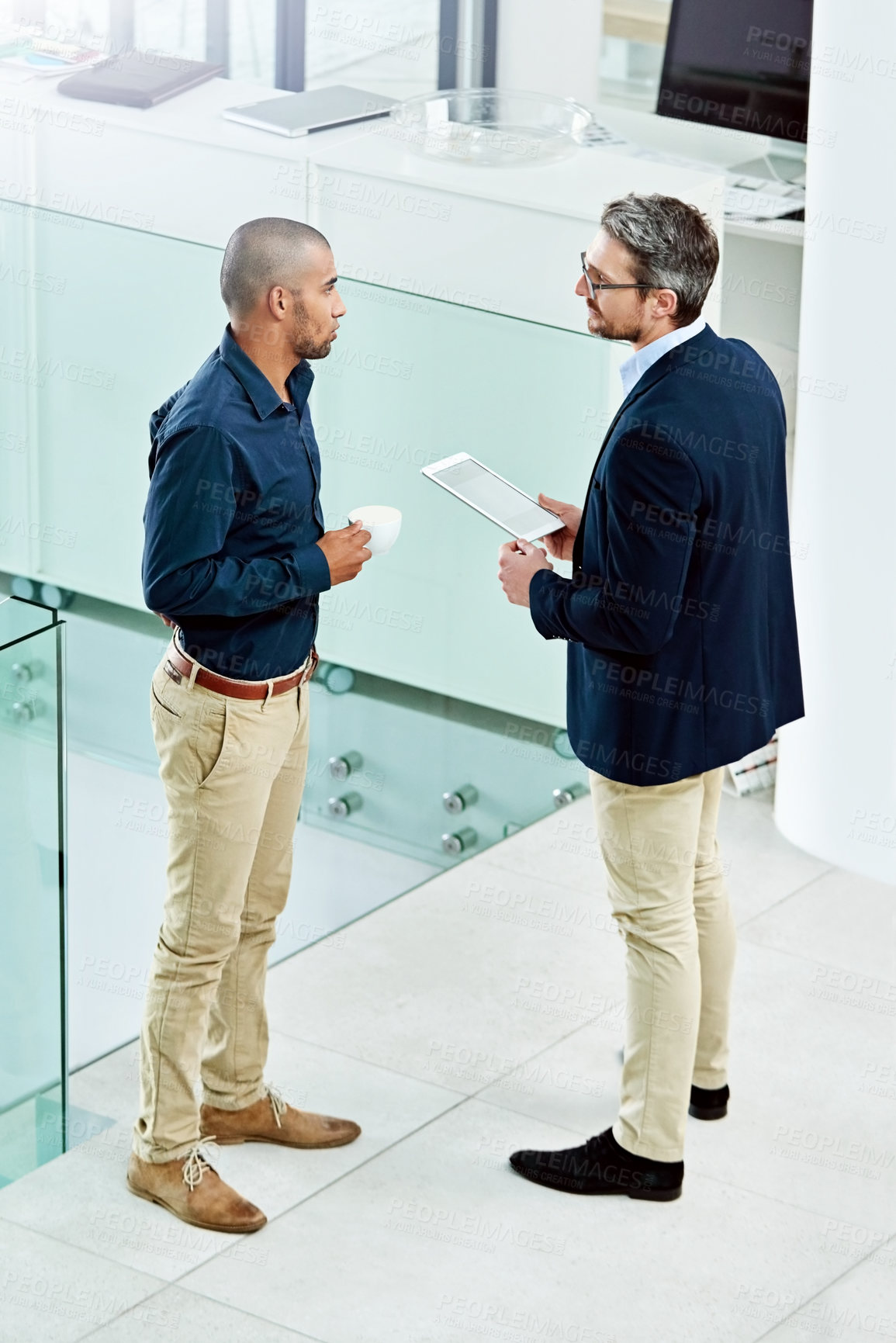 Buy stock photo Business people, tablet and talk in lobby on project, teamwork and online research for discussion. Employees, high angle and drinking coffee for support, collaboration and working together on idea