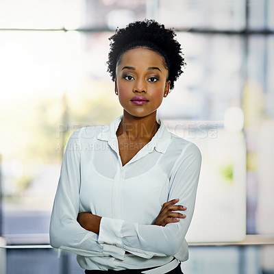 Buy stock photo Portrait of a young businesswoman standing with her arms folded in the office