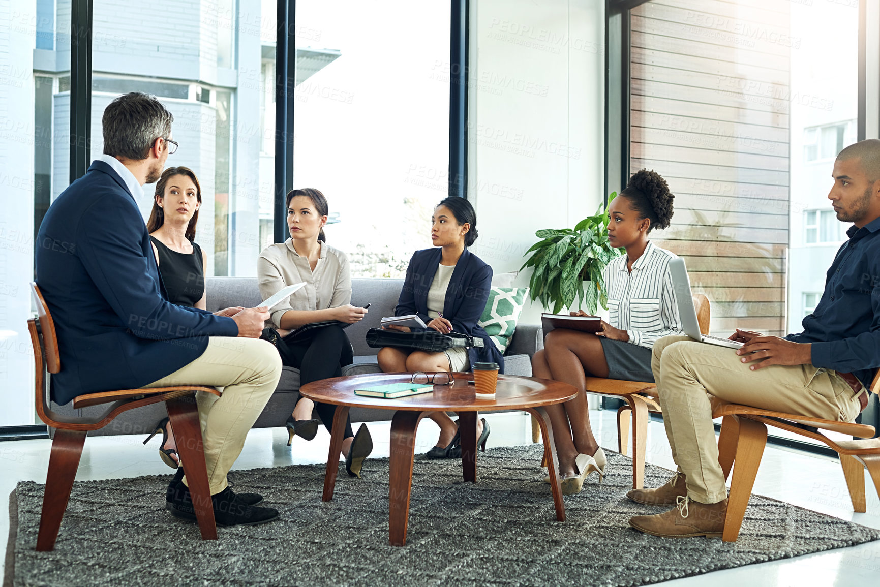 Buy stock photo Shot of a group of work colleagues talking together in a meeting in an office