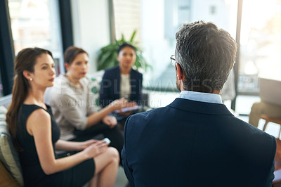 Buy stock photo Shot of a group of businesspeople listening to their manager during a meeting