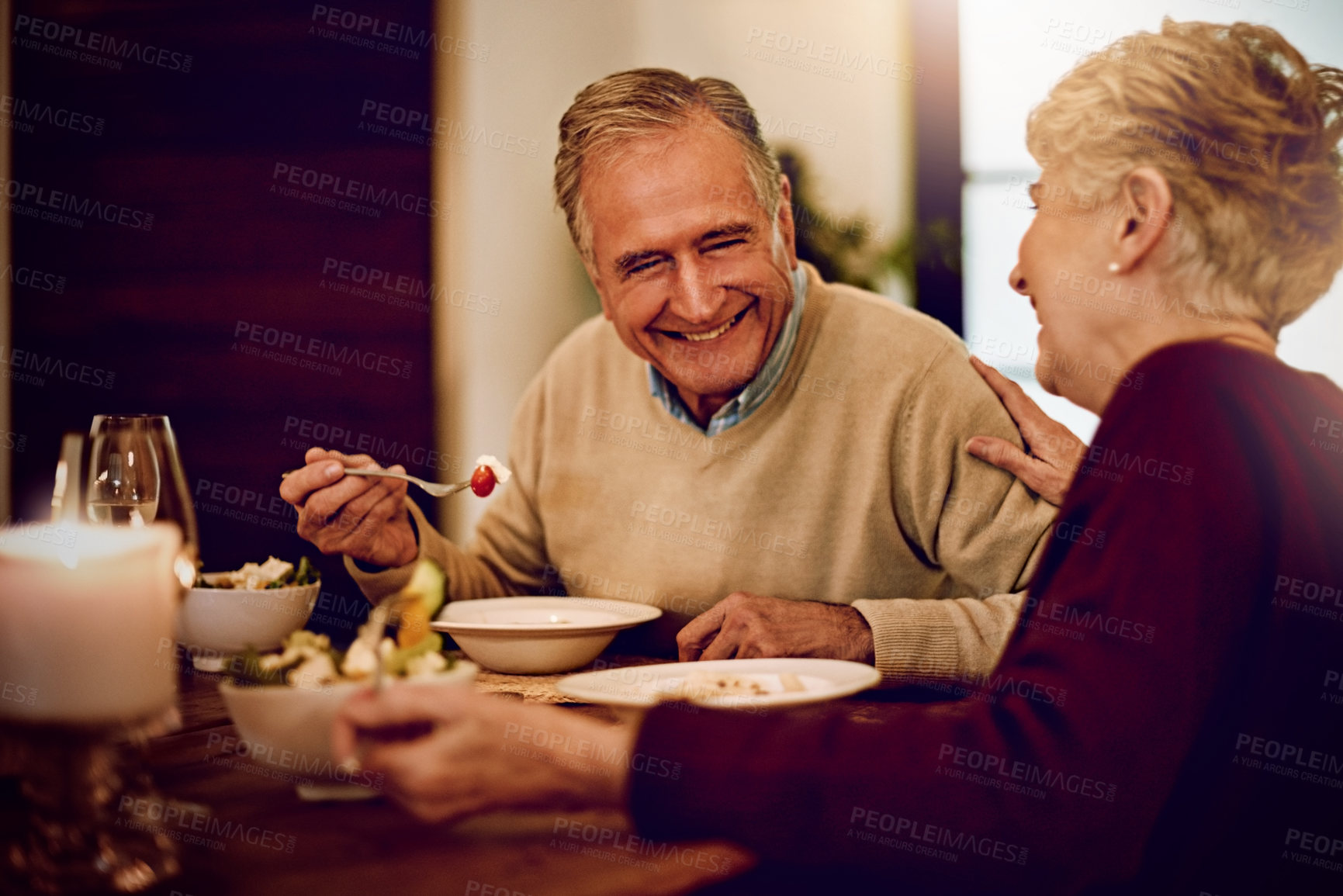 Buy stock photo Shot of an elderly couple enjoying a meal and wine together at home