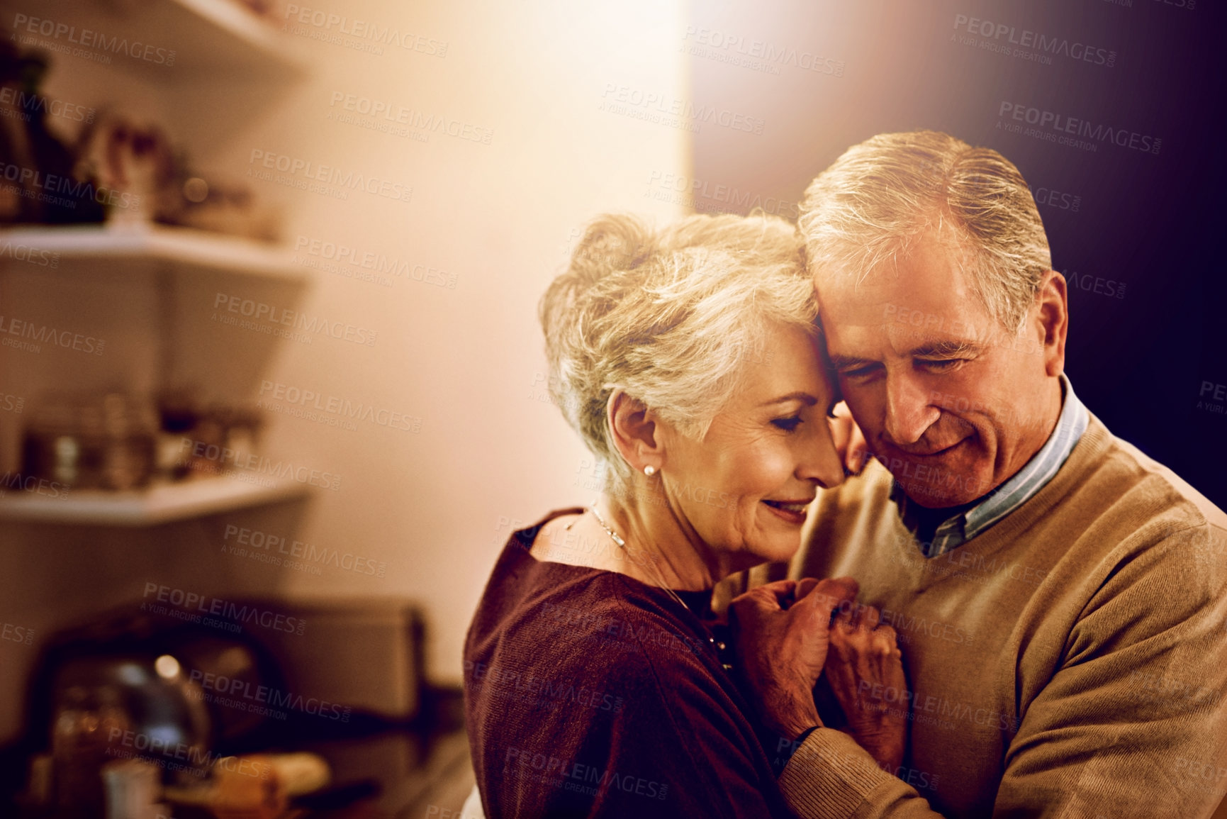 Buy stock photo Shot of an elderly couple dancing with each other in their kitchen