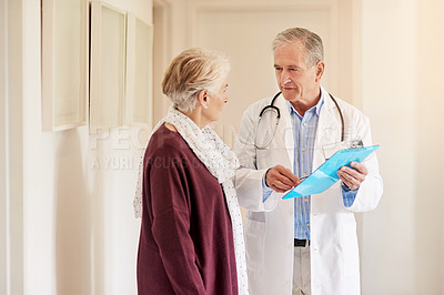 Buy stock photo Shot of a doctor having a conversation with his patient in the clinic