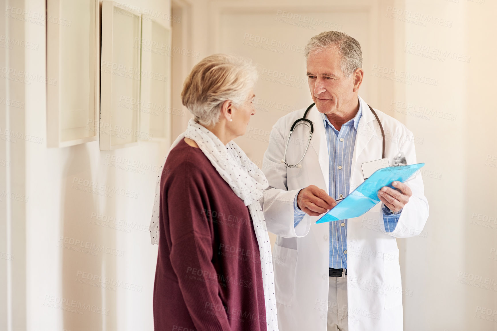 Buy stock photo Shot of a doctor having a conversation with his patient in the clinic