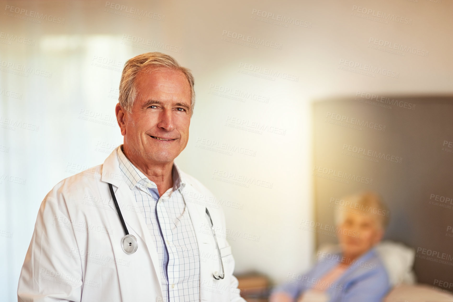 Buy stock photo Portrait of a mature doctor with his patient in bed in the background