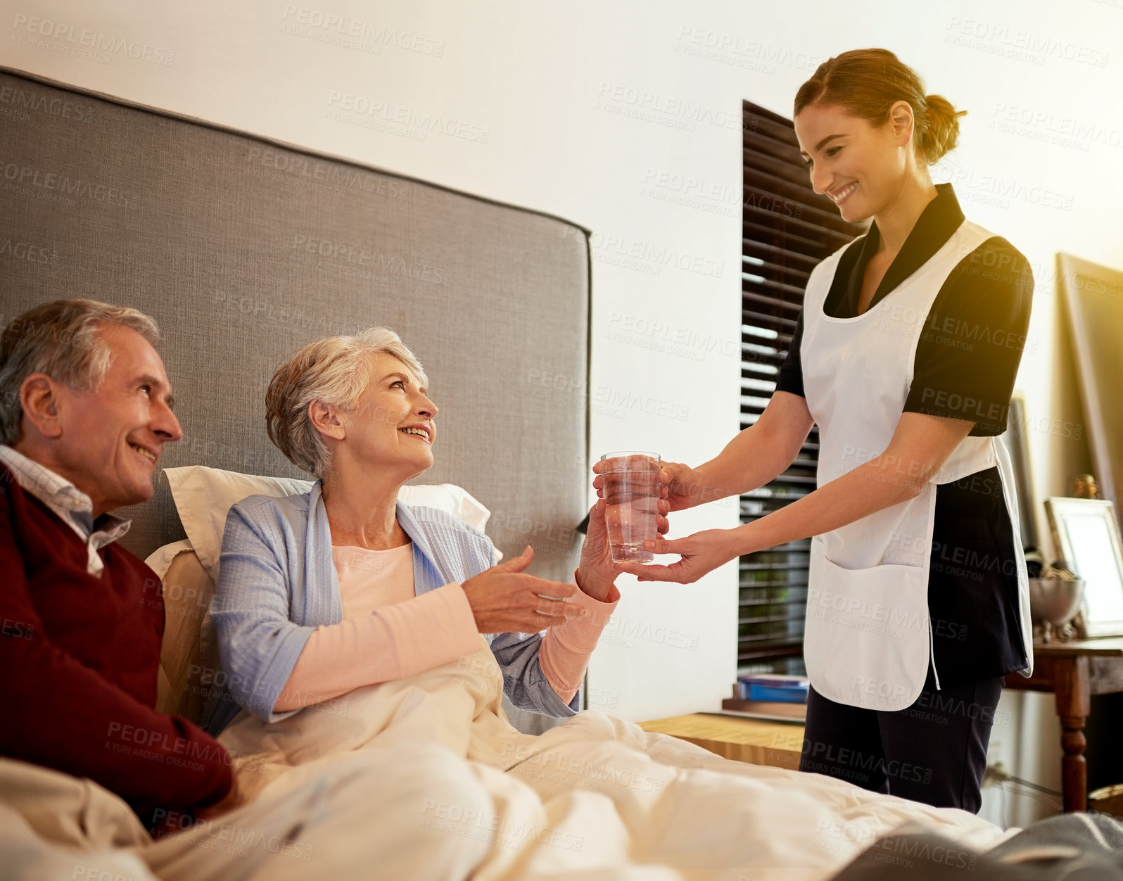 Buy stock photo Shot of a nurse assisting and elderly patient and her husband in their room