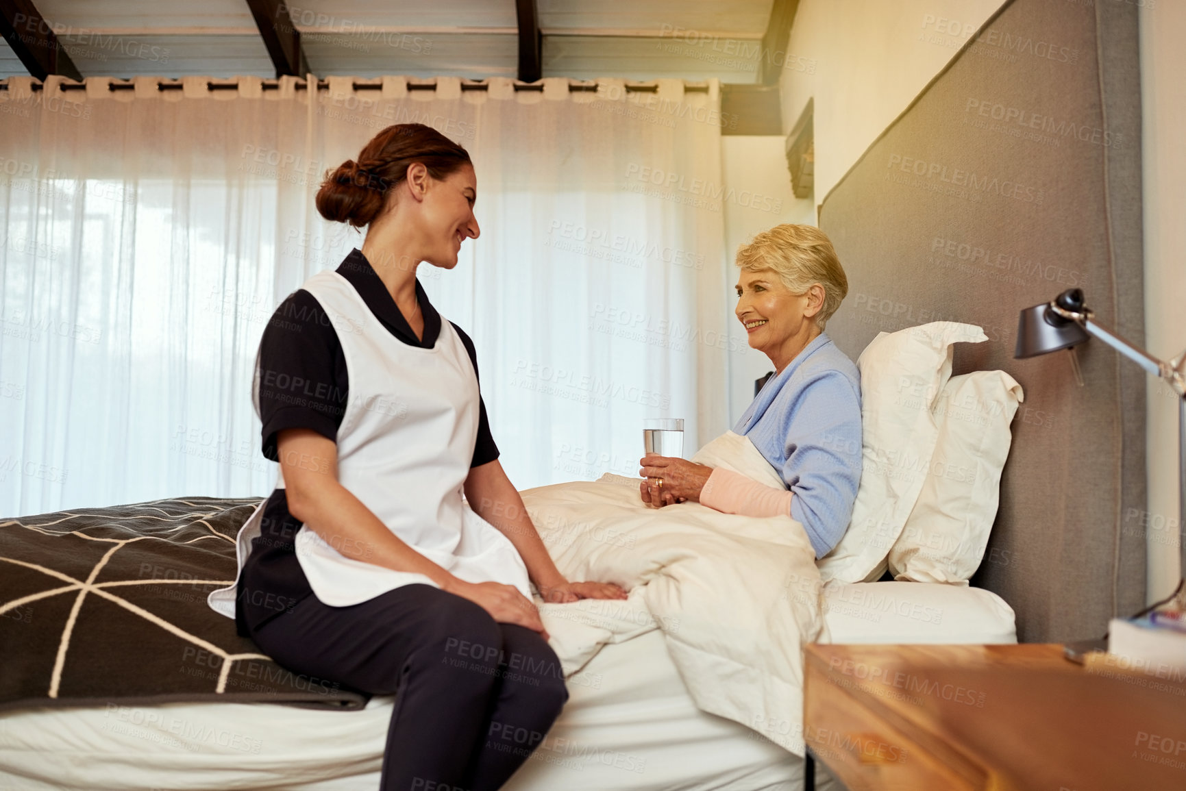 Buy stock photo Shot of a nurse sitting with her elderly patient in her room