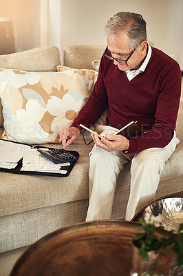 Buy stock photo Shot of a senior man working out a budget while sitting on the living room sofa