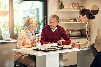 Buy stock photo Shot of a senior couple getting advice from their financial consultant